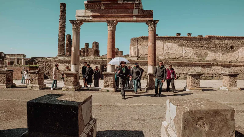 Travellers walking through the Forum toward the Temple of Jupiter on Pompeii tours from Rome by high-speed train that add Herculaneum, Italy